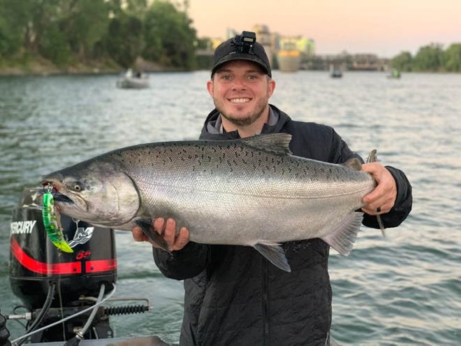 Kyle Keith of Sacramento shows off a 22-pound chinook salmon caught on the Sacramento River below the mouth of the American River at Discovery Park on July 16.