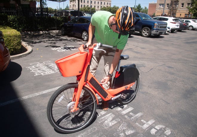 Stockton Mobility Collective assistant planner Jay Halva demonstrates an electric assisted bike at the San Joaquin County of Governments office in downtown Stockton.