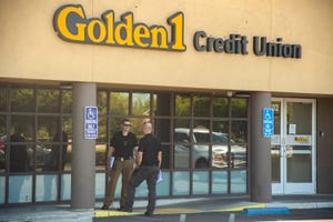 A Stockton Police detectives talk at a homicide scene outside of the Golden 1 Credit Union at the Sherwood Mall in Stockton.  Before 11 am police received a report of a shooting outside of the credit union.  Officers located an adult male who had been shot.  Medics declared him dead at the scene.