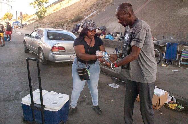 Wilisha Cherry, founder of the Stockton nonprofit Fruitful Cherry, hands out free ice-cold water bottles to the homeless people on Church Street near Lincoln Street in downtown Stockton to help mitigate triple-digit temperatures on Wednesday, Sept. 7, 2022.