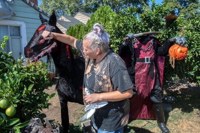 Jeanna Pack works on the Headless Horseman and his steed Halloween decorations in her front yard on Oro Avenue near Farm Street in east Stockton on Thursday, Sept. 22, 2022. Pack has been doing elaborate Halloween displays at her home for the past 26 years.