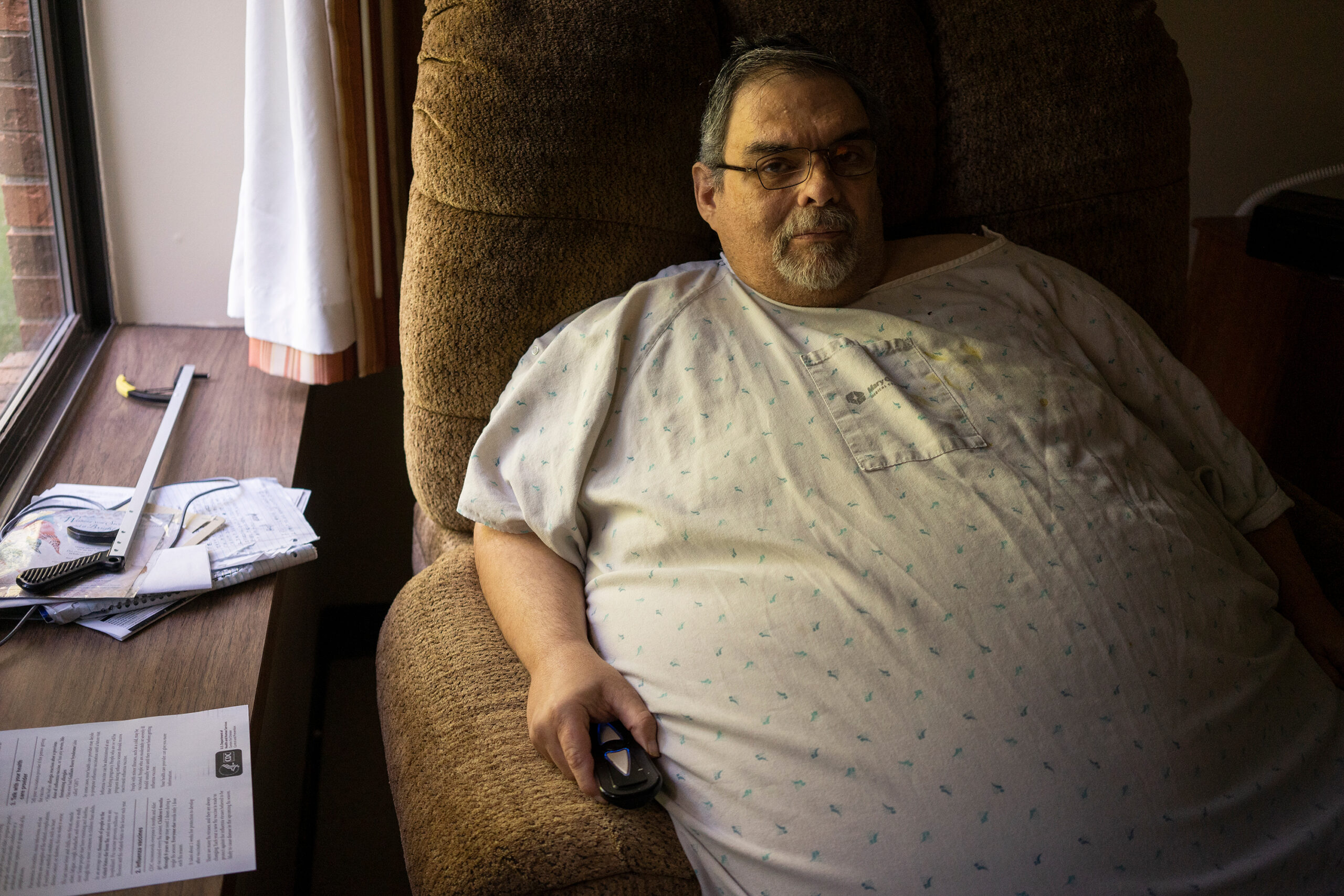 A photo shows Jeff White sitting in the nursing home where he lives, looking at the camera.