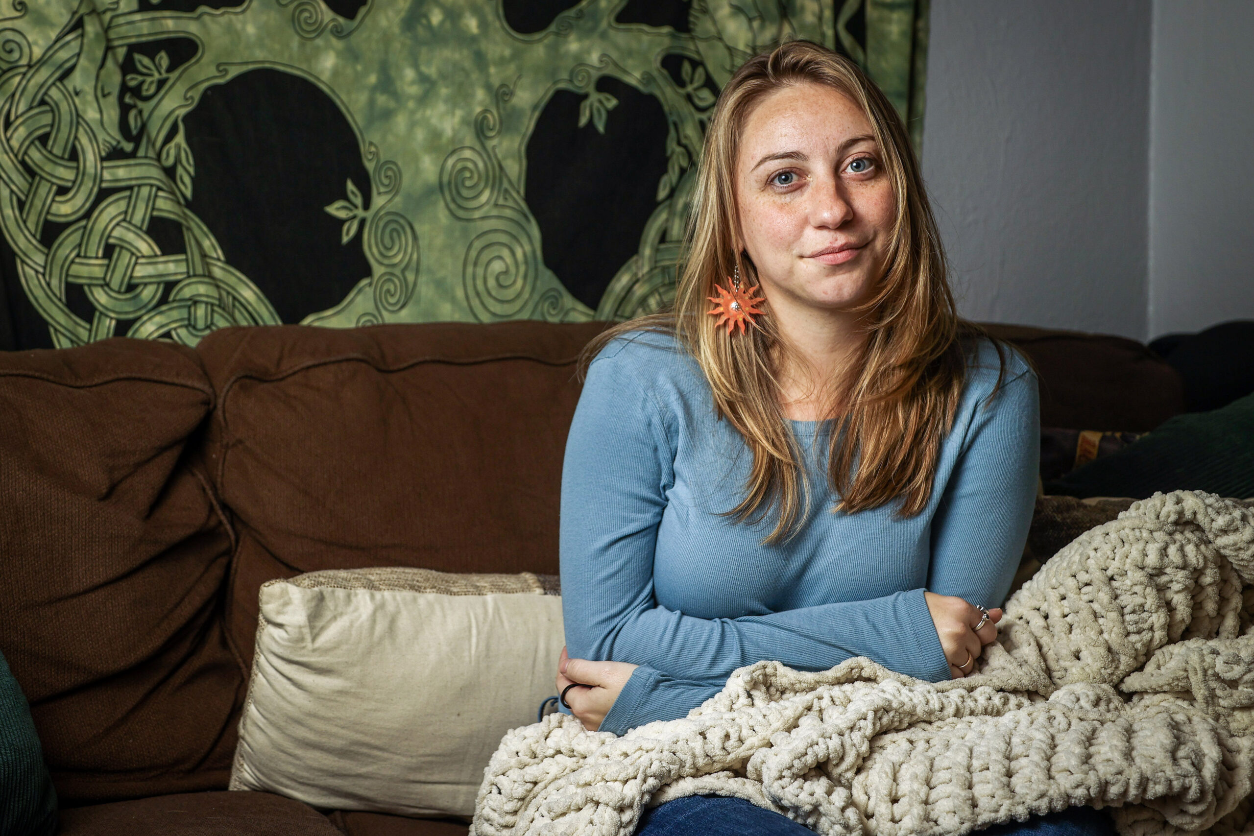 Nina Shand sits on a couch in her home.